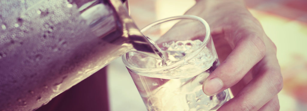 Person pouring a glass of water