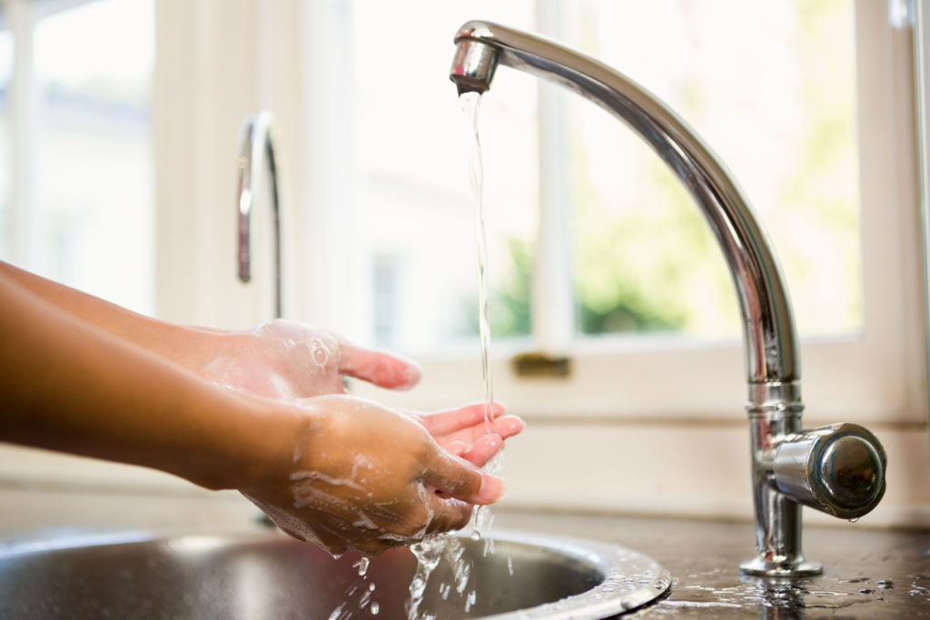 51522231 - mid section of woman washing hands in the kitchen